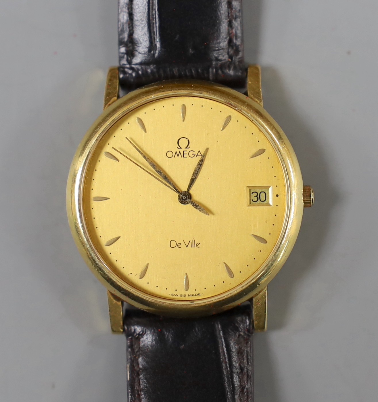 A gentleman's 18ct gold Omega De Ville quartz wrist watch, on associated leather strap, with Omega box.